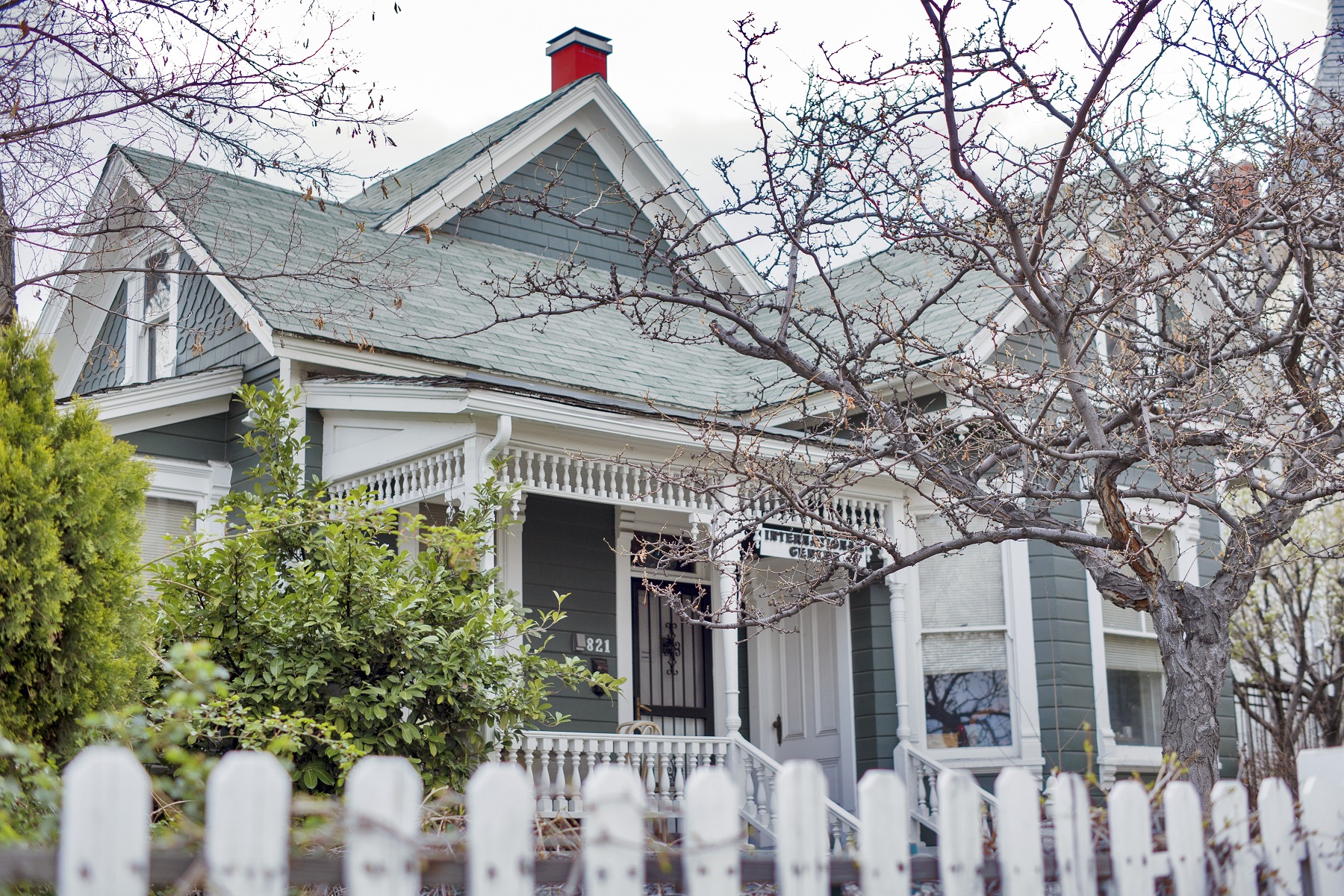 821 is a one story blue house with craftsman finishes and a white picket fence.